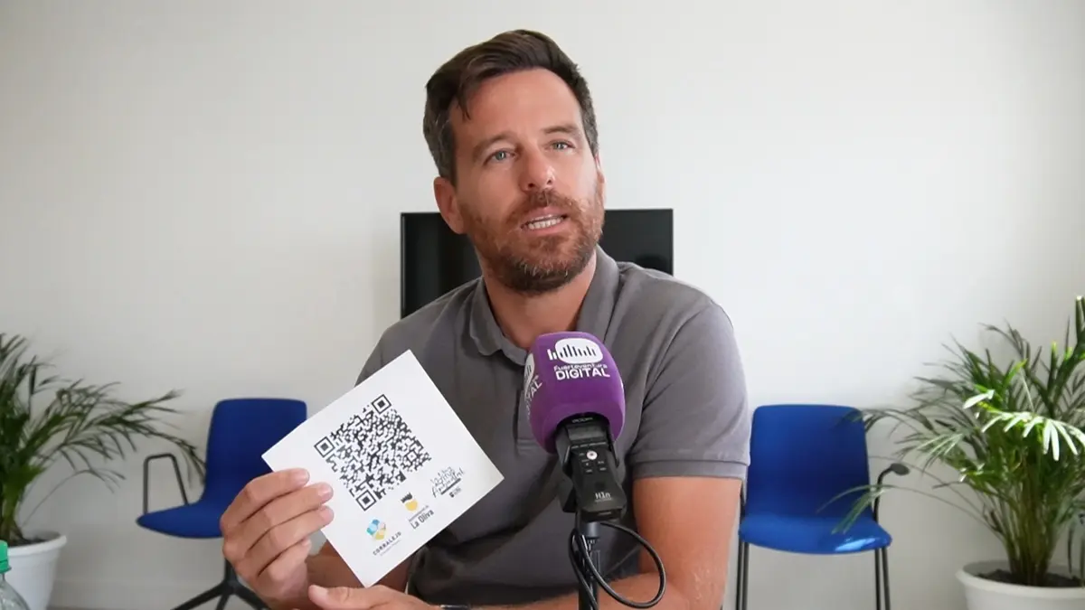 David Fajardo muestra el código QR de la campaña ambiental.