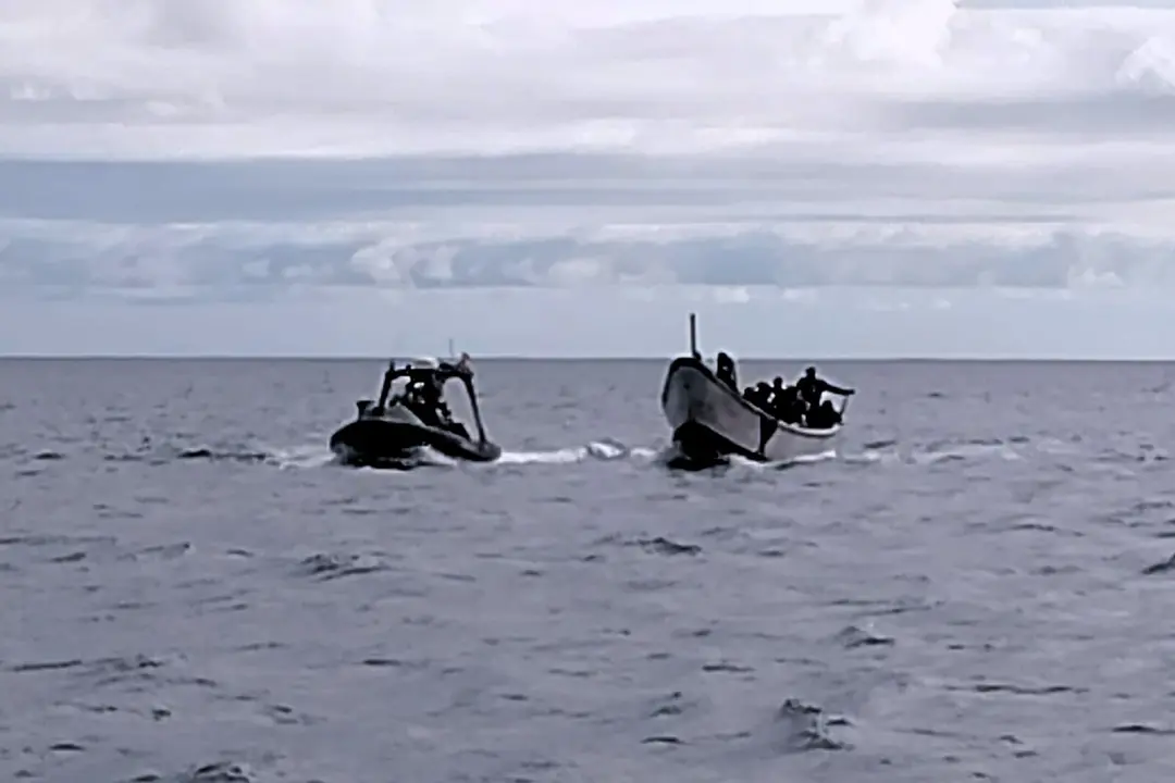 Cayuco escoltado por la Guardia Civil cerca de El Hierro, en una imagen captada por Salvamento Mar&iacute;timo.