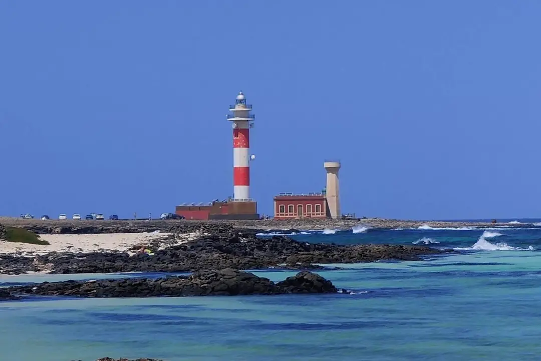 La caleta del Marrajo, en El Cotillo, con el Faro del Tost&oacute;n al fondo | &copy;Fuerteventura Digital, 2021.