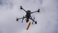 Dron de salvamento soltando un salvavidas.