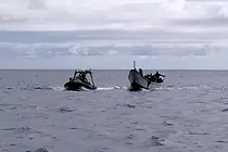 Cayuco escoltado por la Guardia Civil cerca de El Hierro, en una imagen captada por Salvamento Mar&iacute;timo.