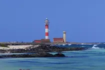 La caleta del Marrajo, en El Cotillo, con el Faro del Tost&oacute;n al fondo | &copy;Fuerteventura Digital, 2021.