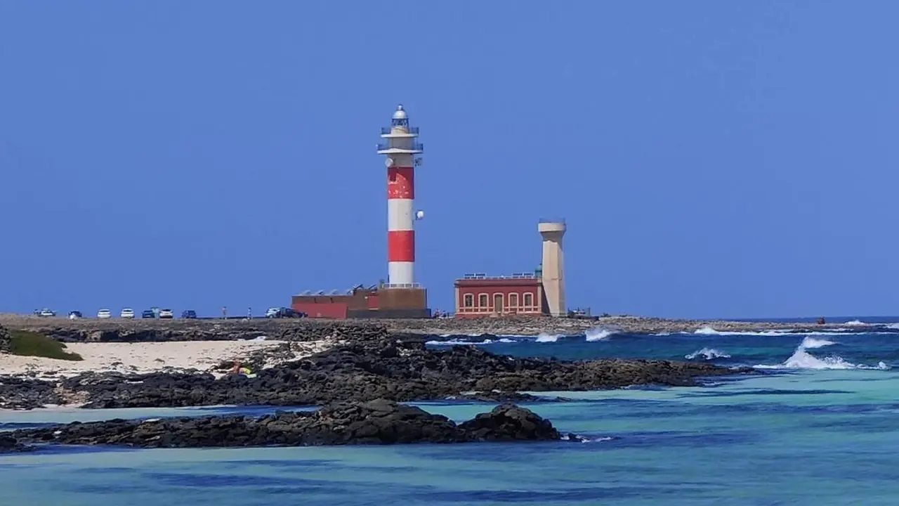 La caleta del Marrajo, en El Cotillo, con el Faro del Tost&oacute;n al fondo | &copy;Fuerteventura Digital, 2021.