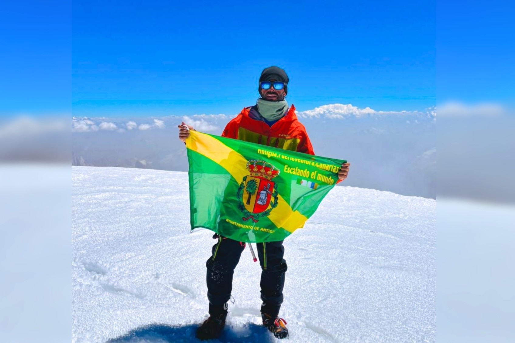 Placeres en Pakistán, posando con la bandera de Antigua.