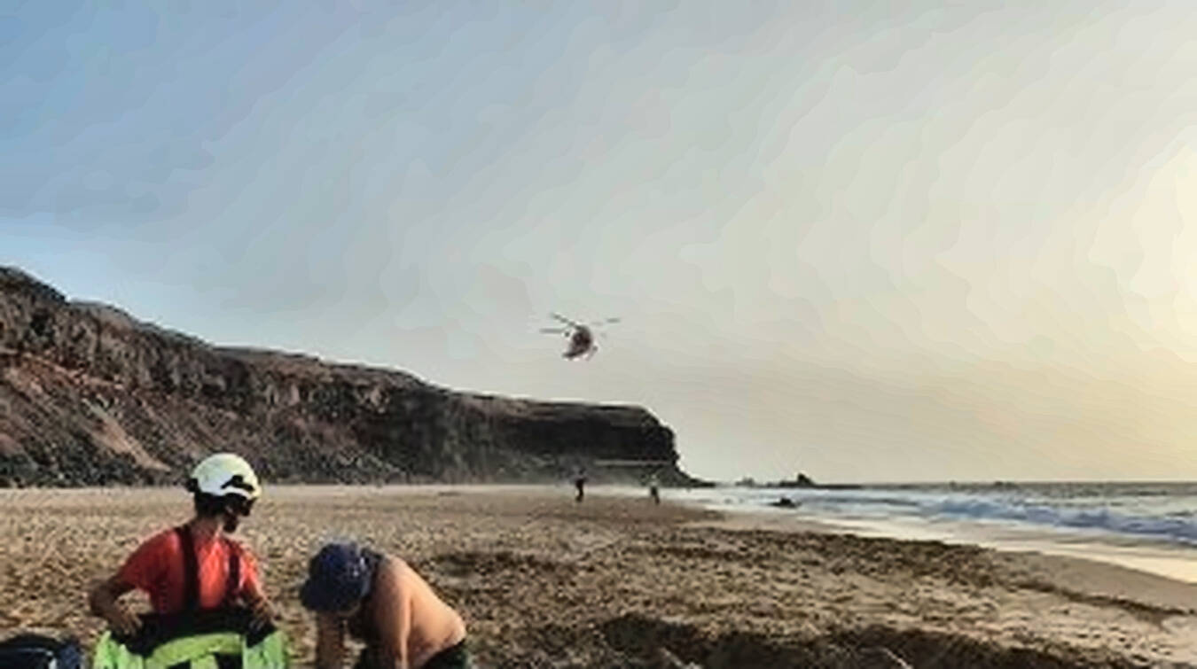 Atención en tierra al bañista accidentado en la Playa del Águila (La Escalera), previa a su traslado en helicóptero.